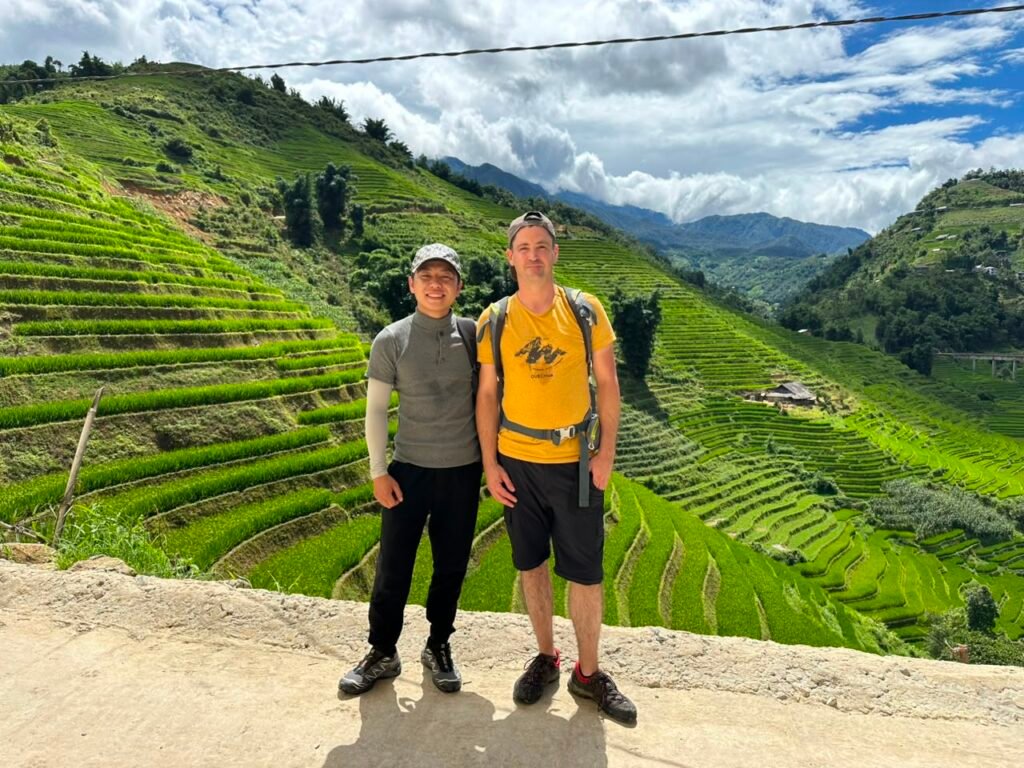 Guide Hmong francophone avec un voyageur dans les rizières en terrasses de la vallée de Muong Hoa à Sapa