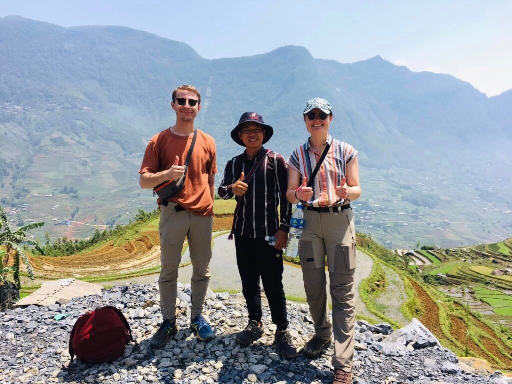 Petit groupe de voyageurs en trek avec un guide Hmong francophone dans les montagnes de Sapa, Vietnam